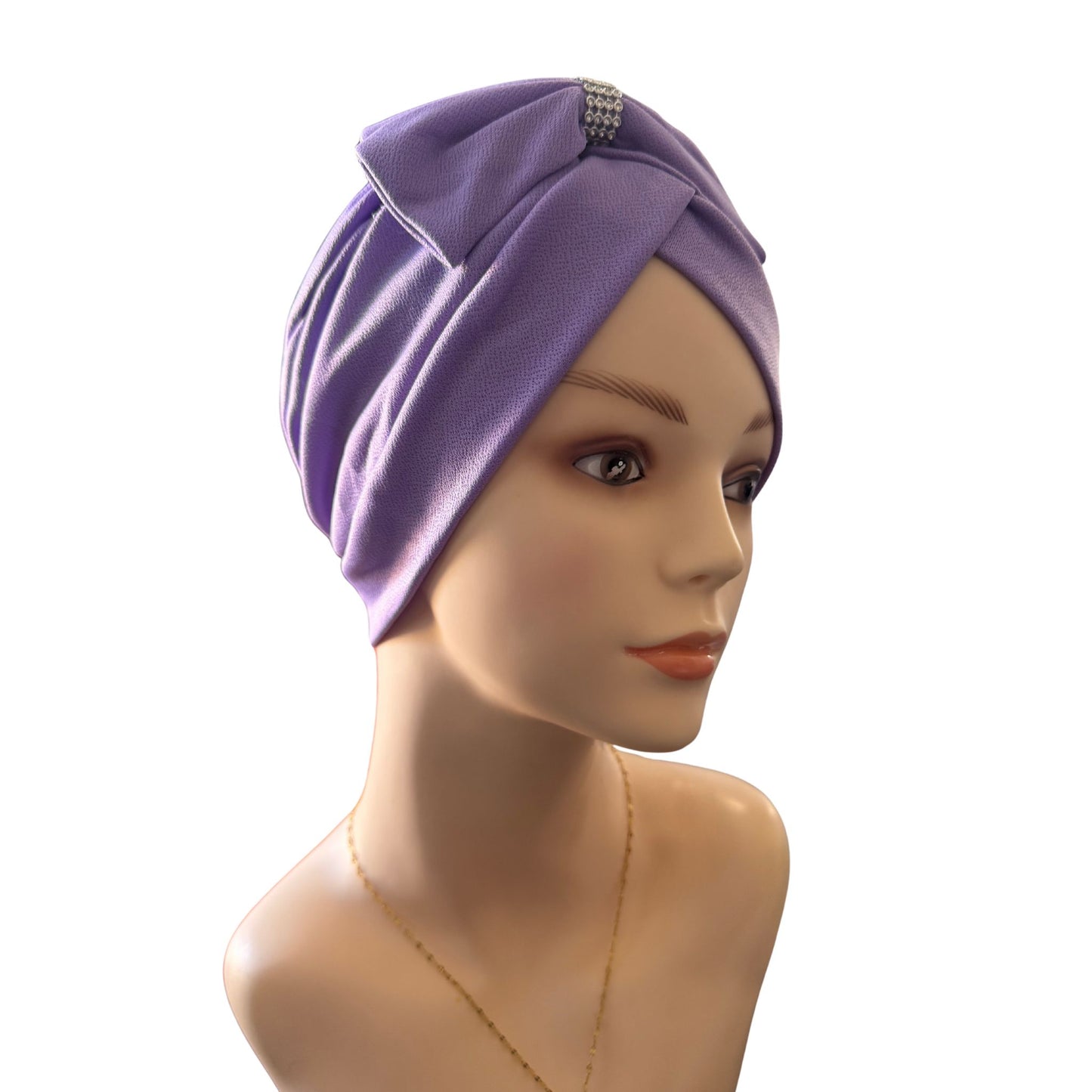 Mannequin head wearing a purple turban with a decorative bow on a white background