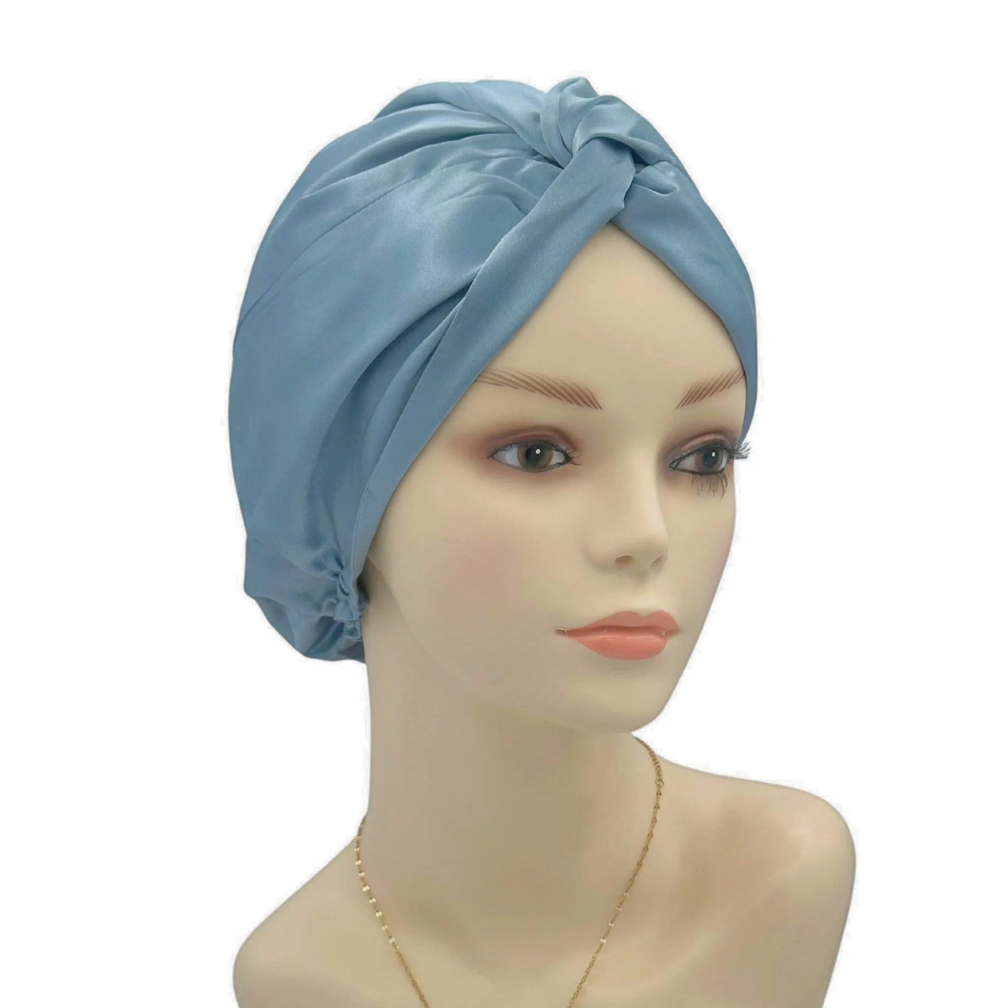 Mannequin head wearing a light blue satin turban on a white background