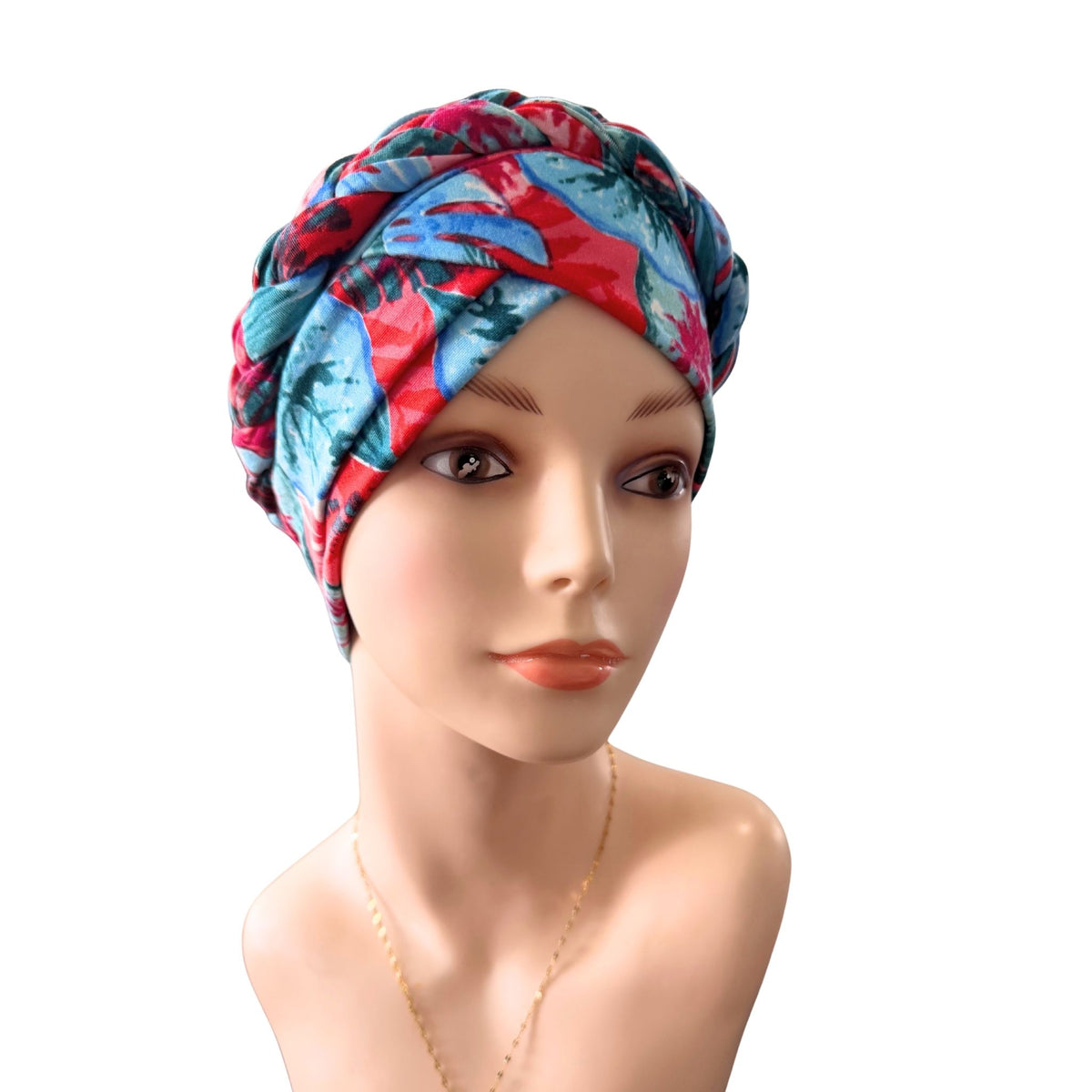 A multicolor tropical leaf print headwrap turban hat displayed on a female mannequin bust against a solid white background.