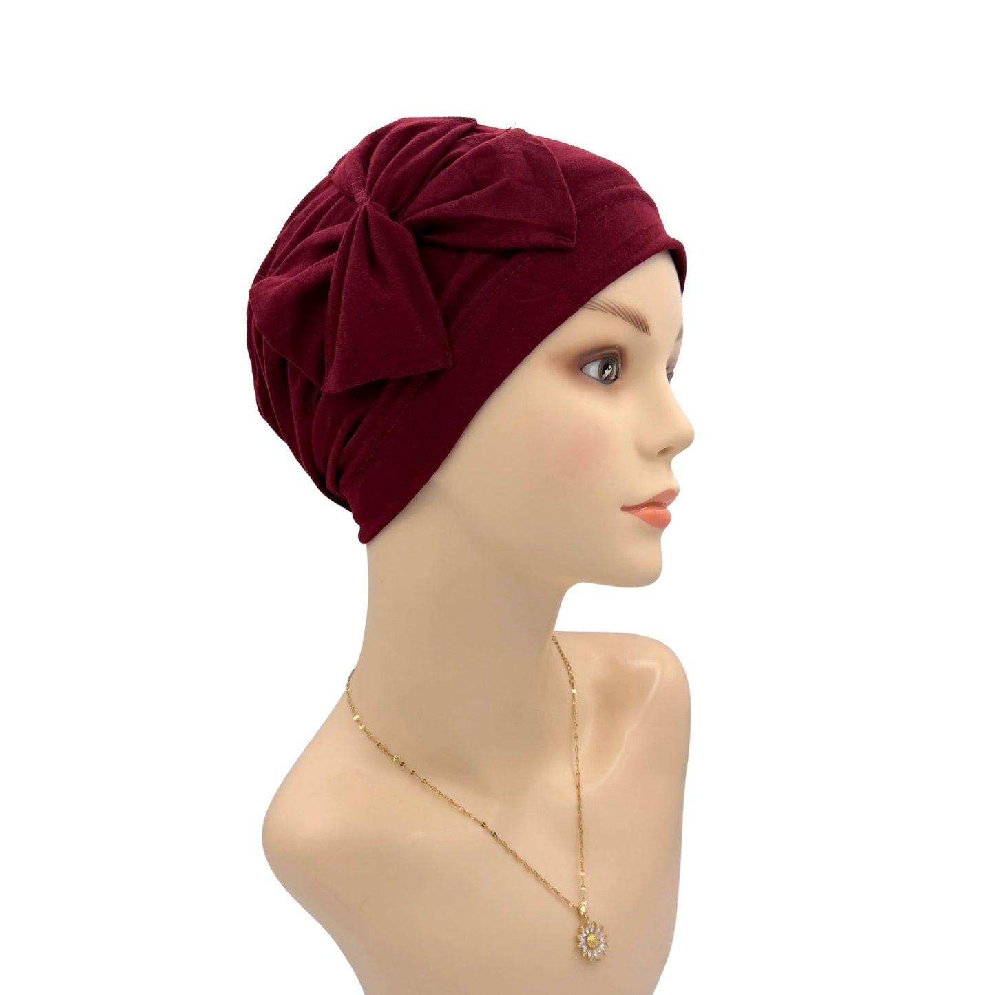 Mannequin head wearing a burgundy turban on a white background