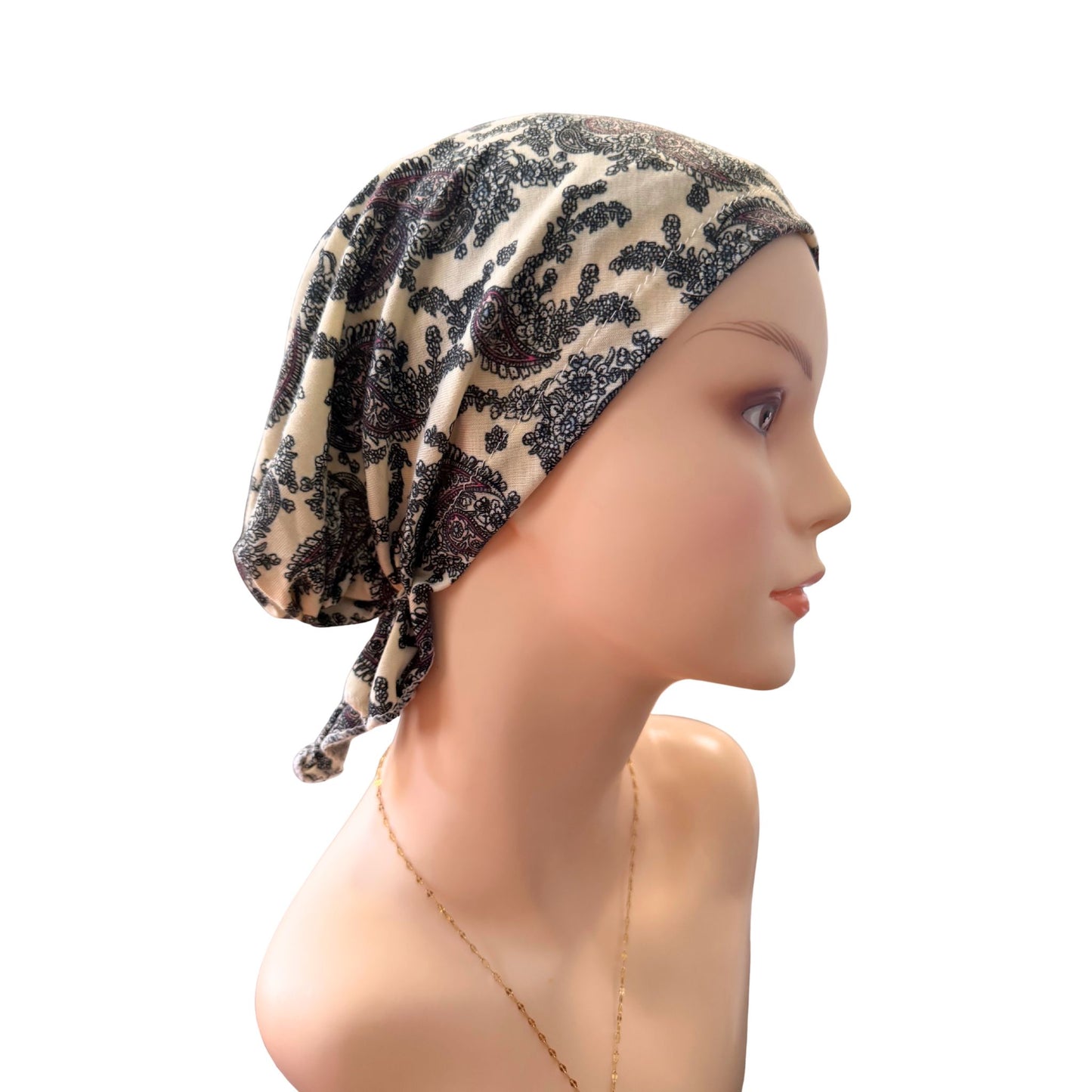 Mannequin head wearing a patterned headscarf on a white background