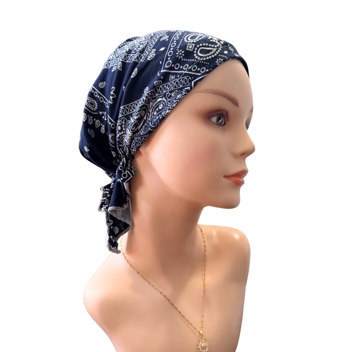 Mannequin head wearing a navy bandana with white patterns on a white background
