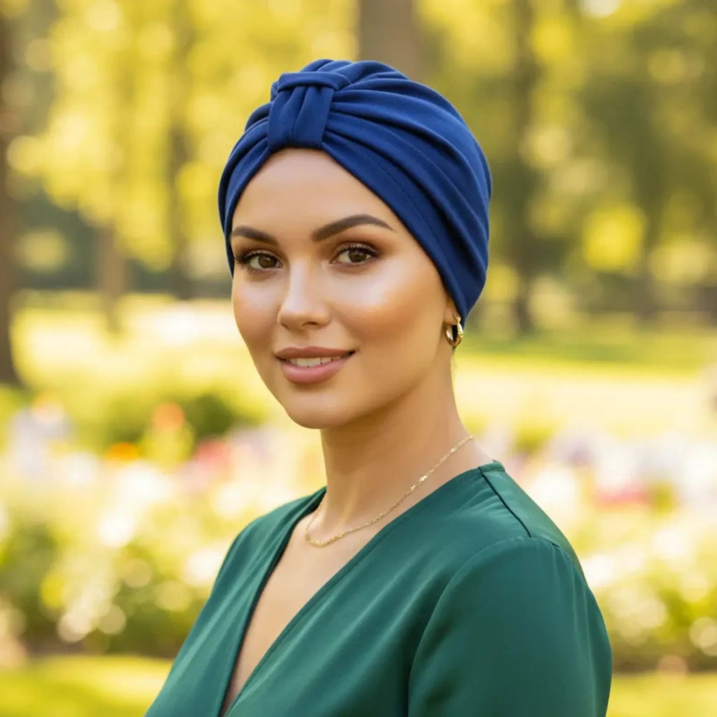 Woman wearing a blue headscarf and green top in a park setting