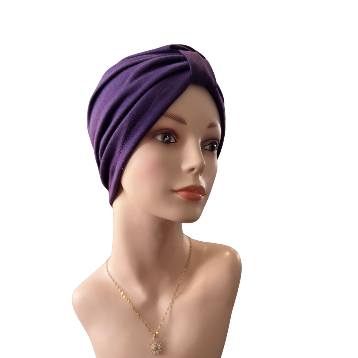 A purple fabric headwrap or turban-style hair cover displayed on a mannequin bust against a plain white background.