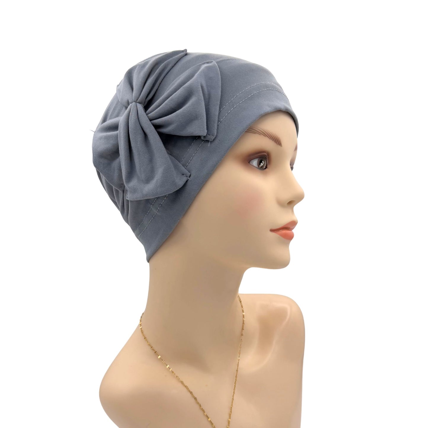 Gray headscarf with a bow on a mannequin head against a white background