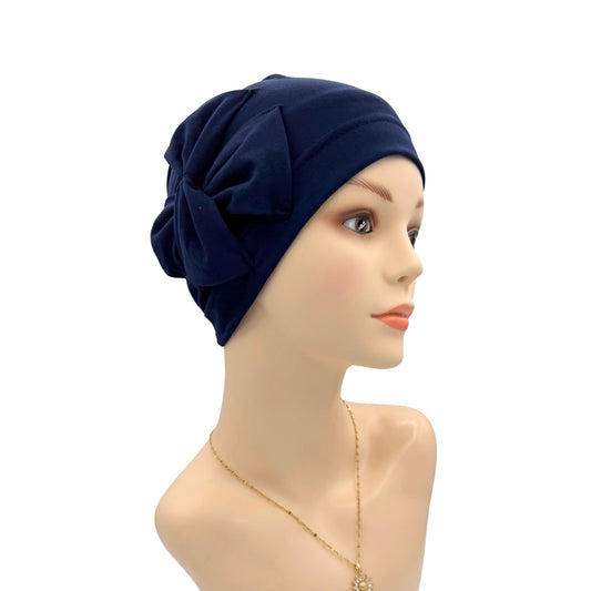 Navy blue headscarf with a bow on a mannequin head against a white background
