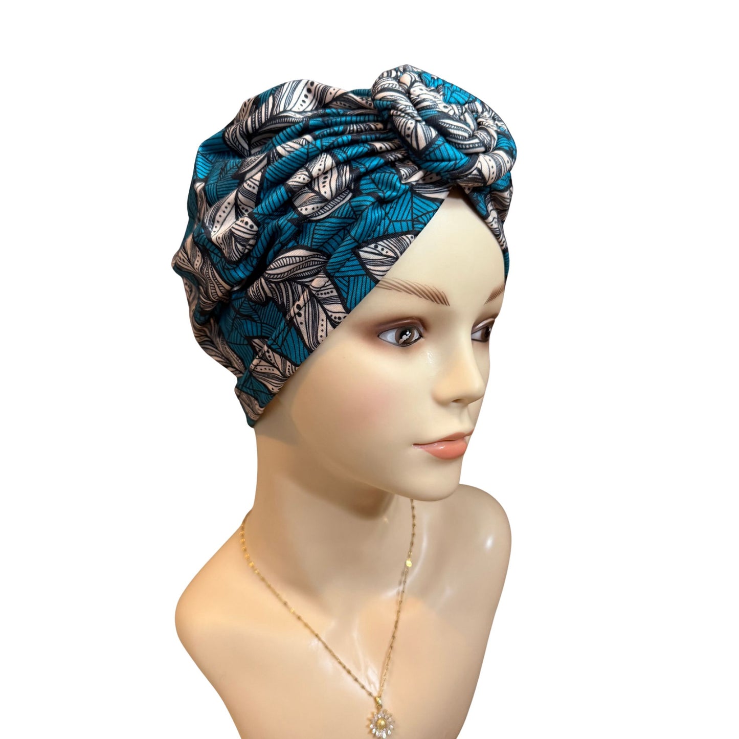 Blue and silver patterned headscarf on a mannequin head against a white background