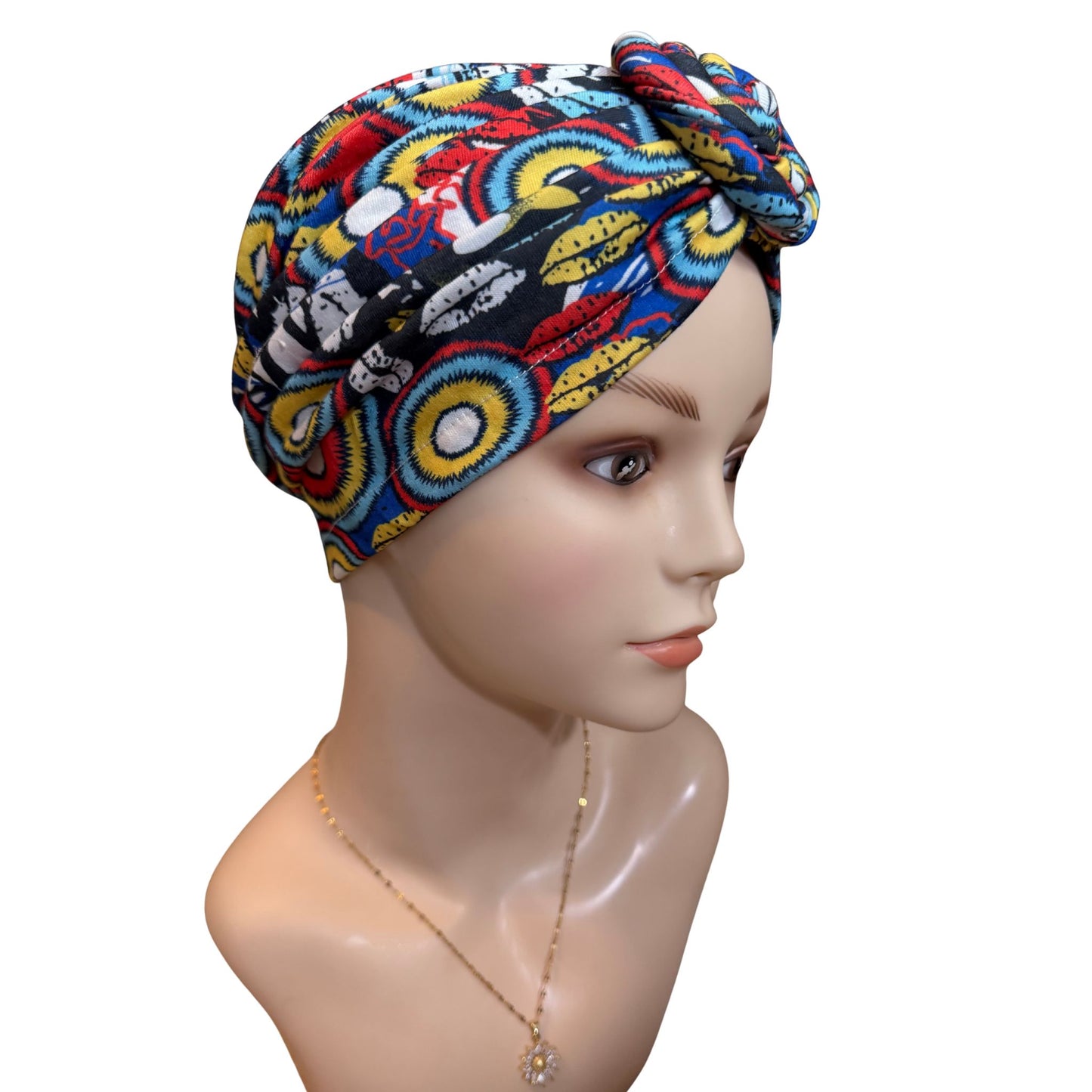 Colorful patterned headscarf on a mannequin head against a white background