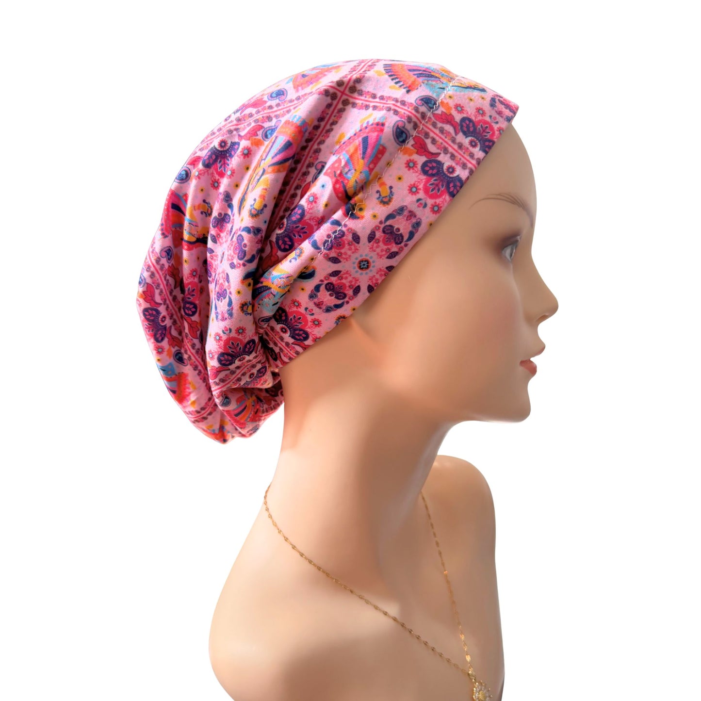 Mannequin head wearing a colorful patterned headscarf on a white background