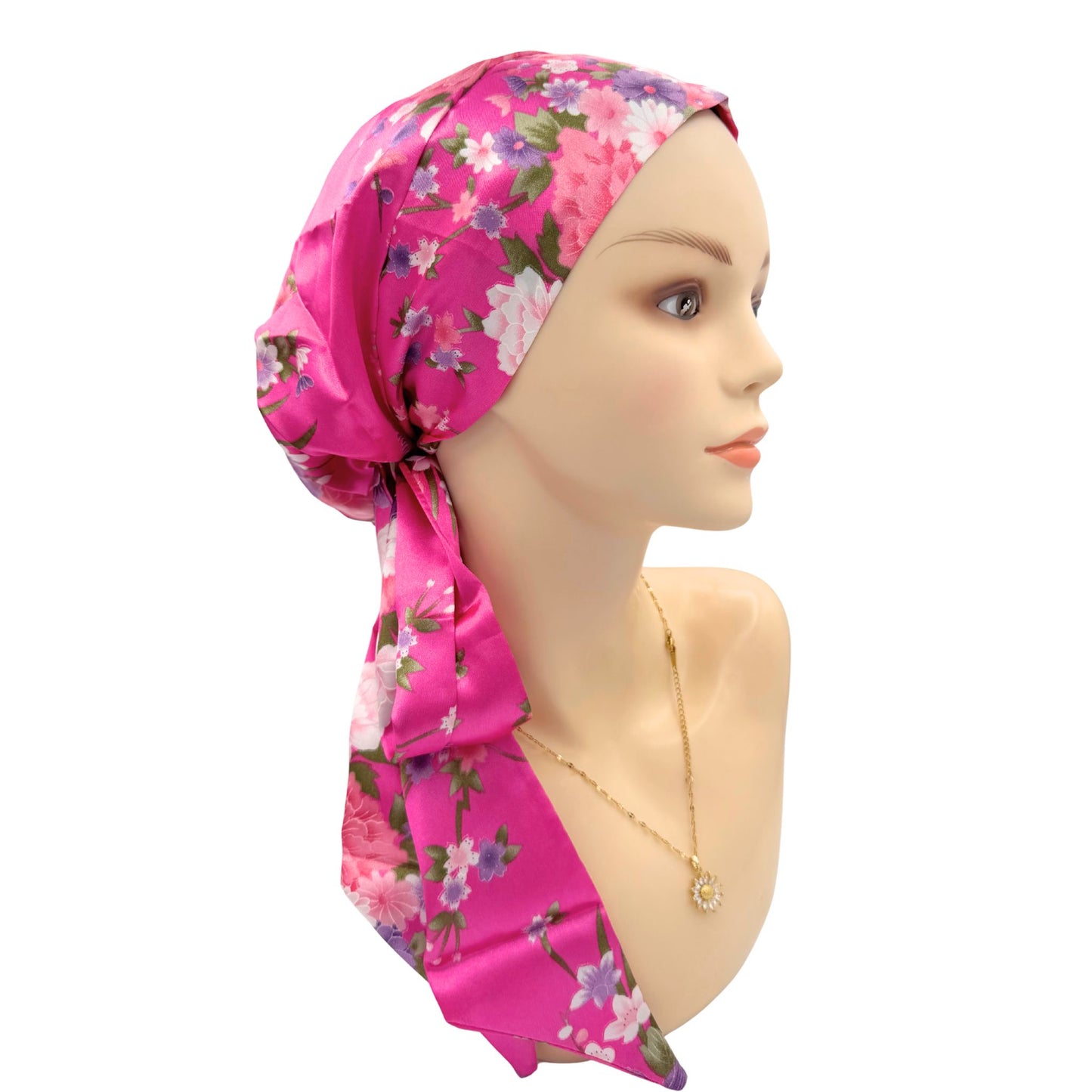 Mannequin head wearing a pink floral headscarf on a white background
