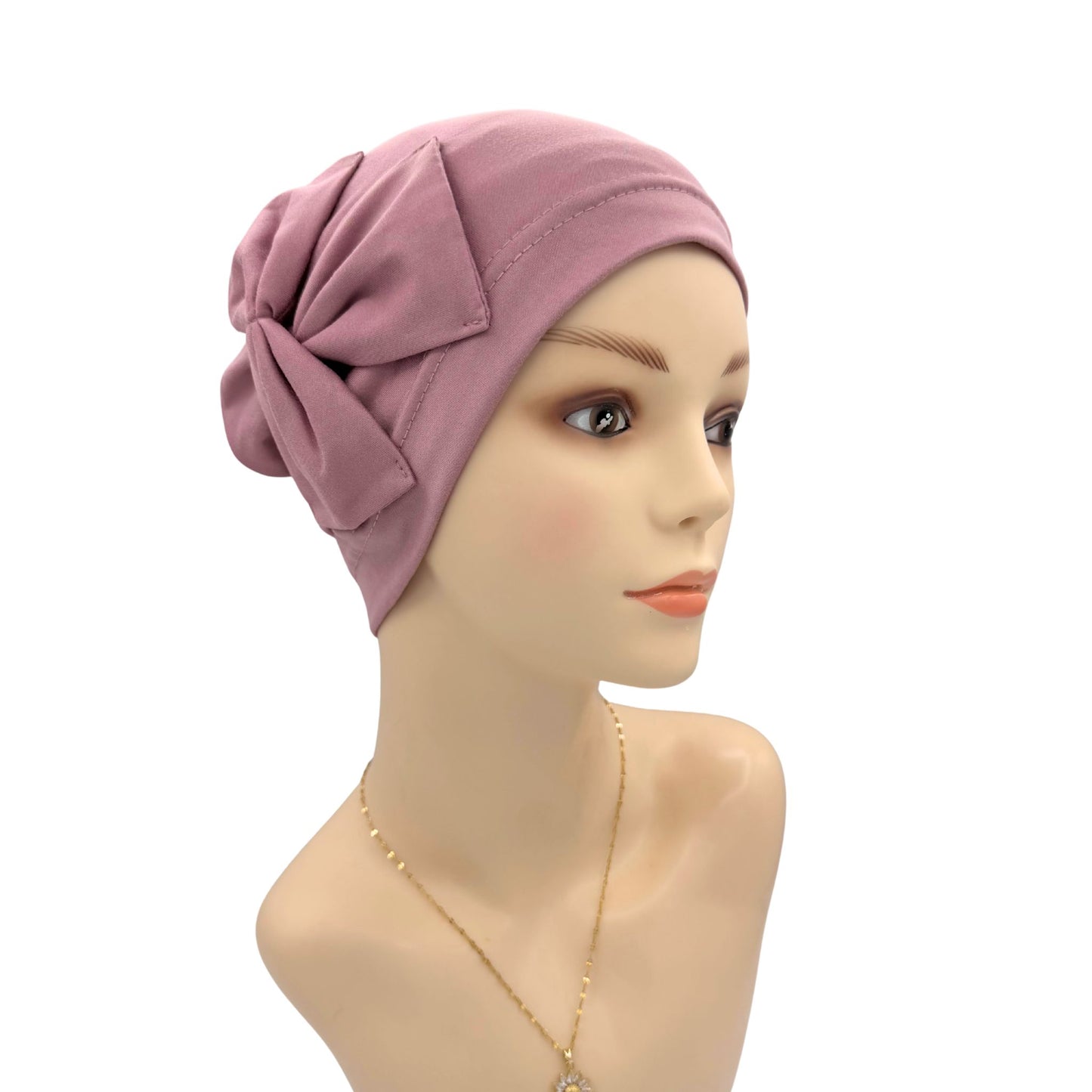 Mannequin head wearing a pink headscarf on a white background