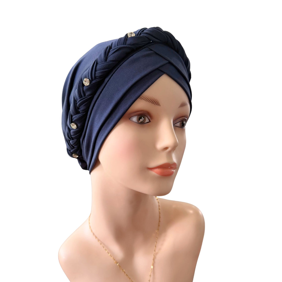 A navy blue twisted turban headscarf with braided detailing and small gold decorative studs, displayed on a mannequin head against a plain white background.