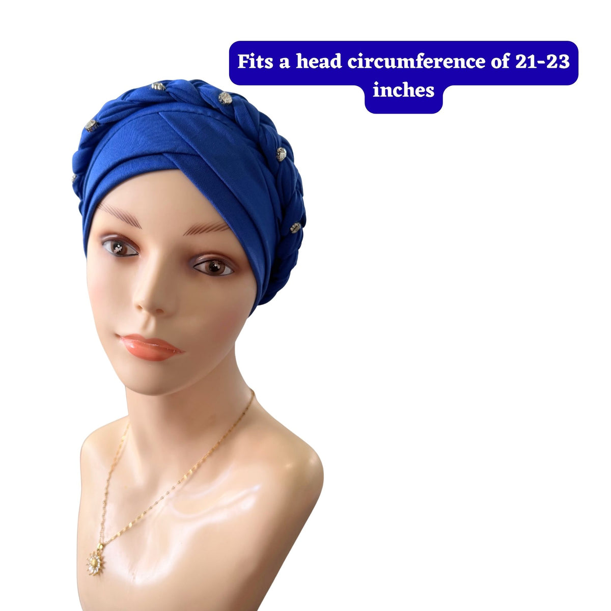 A mannequin bust wearing a royal blue turban-style headwrap with small rhinestone embellishments, on a white background with a blue text box stating 'Fits a head circumference of 21-23 inches'.