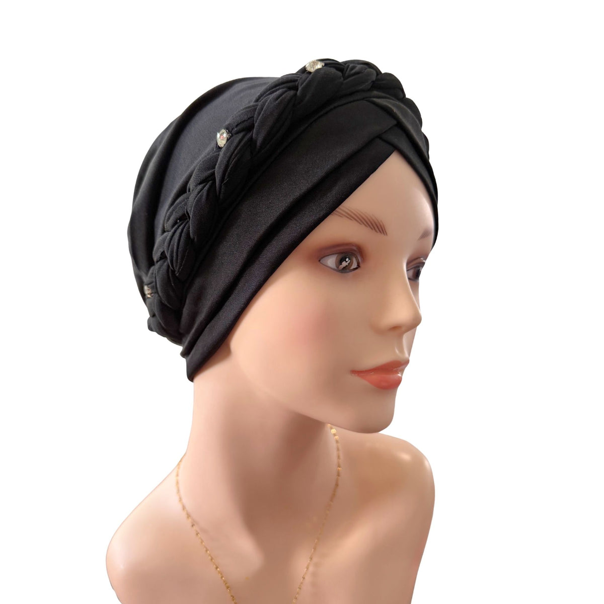 Black braided turban headwrap displayed on a mannequin head against a plain white background.