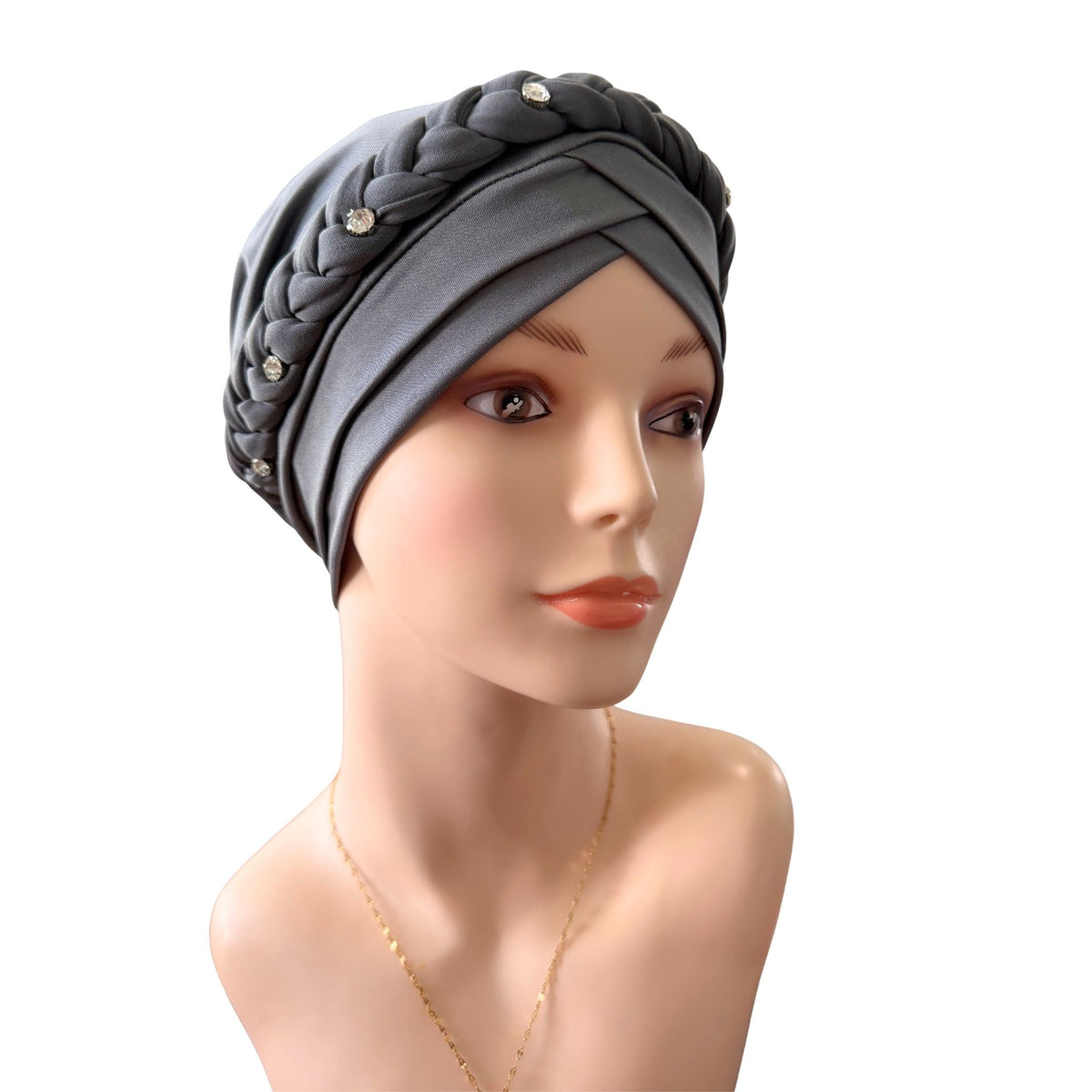 A gray fabric headwrap turban hat with braided detailing and small rhinestone embellishments, displayed on a mannequin bust against a plain white background.