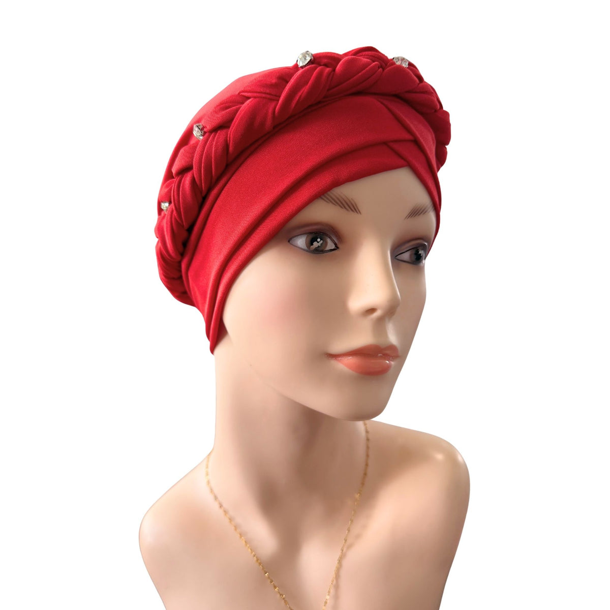 A bright red braided headwrap or turban-style headscarf displayed on a mannequin bust against a plain white background.