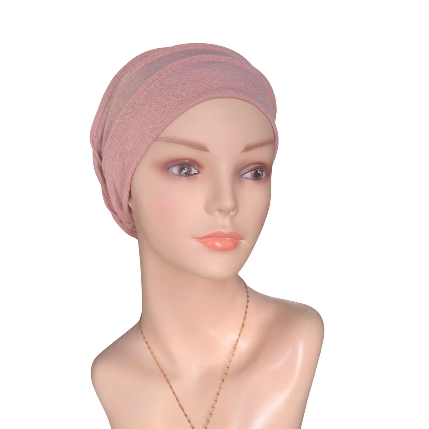 Mannequin head wearing a pink headscarf on a white background