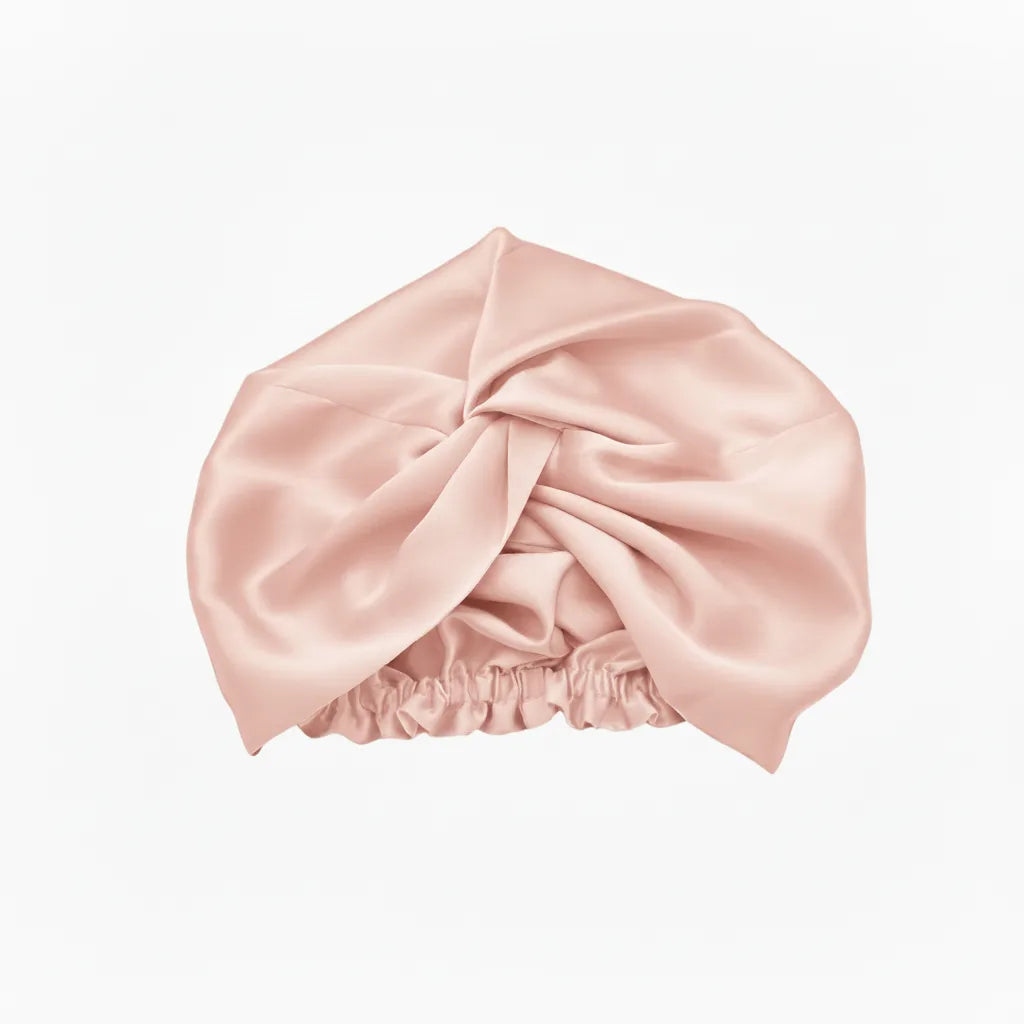 Pink silk bonnet on a white background