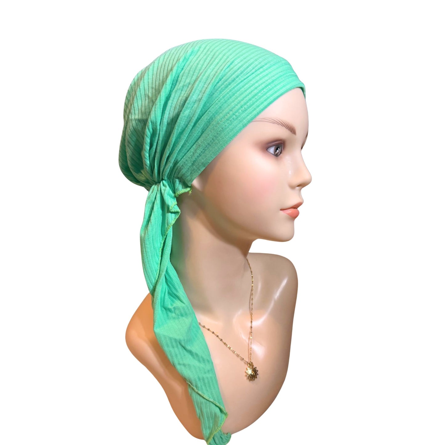 Mannequin head wearing a green headscarf on a white background