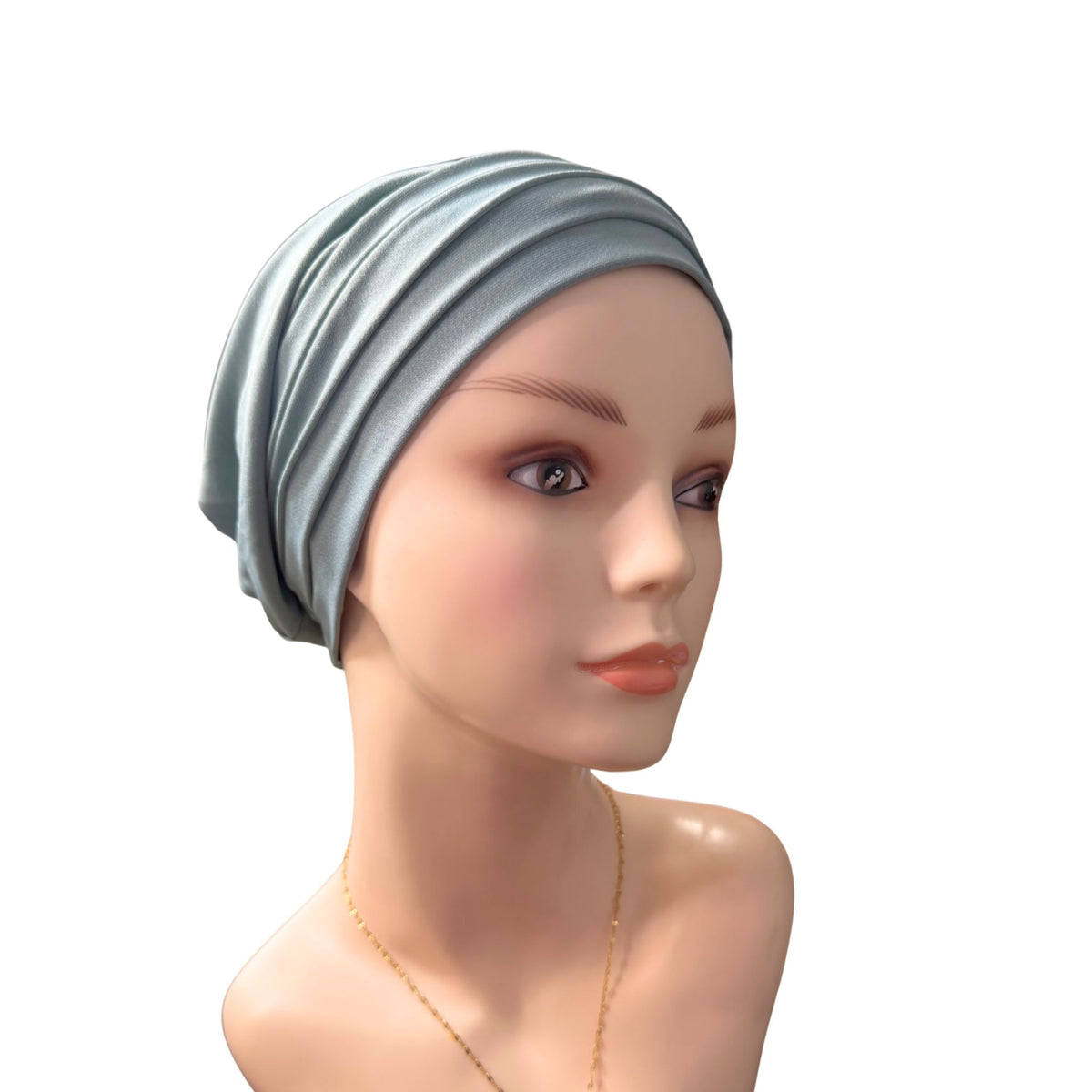 A mannequin wearing a light green Chemo Head Wrap on a white background