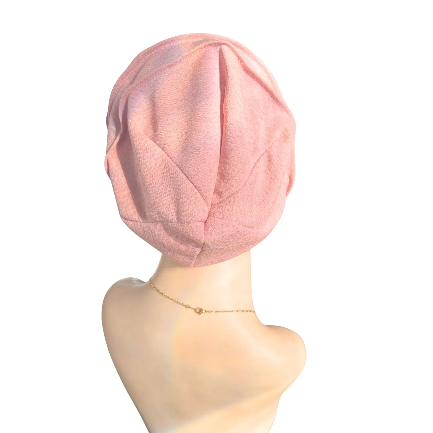 Pink headscarf on a mannequin head against a white background