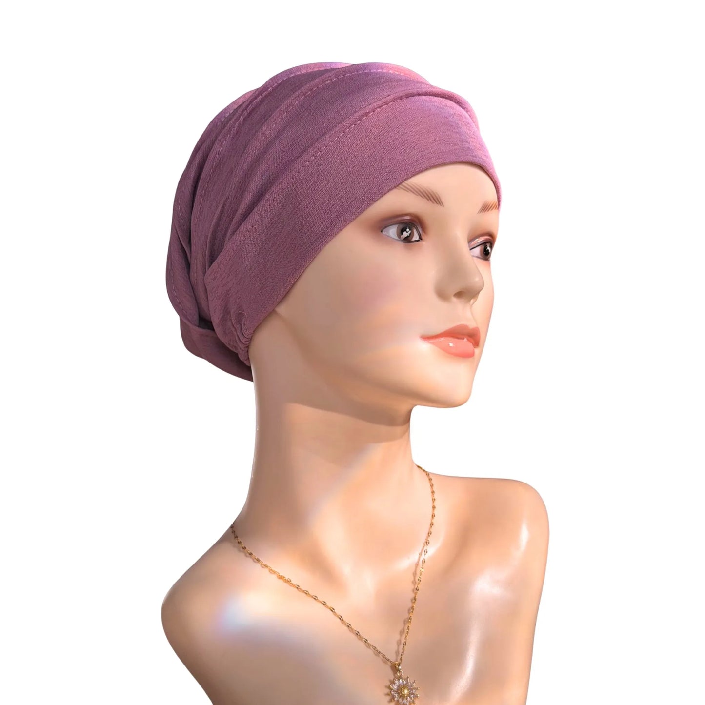 A mannequin wearing a purple turban on a white background