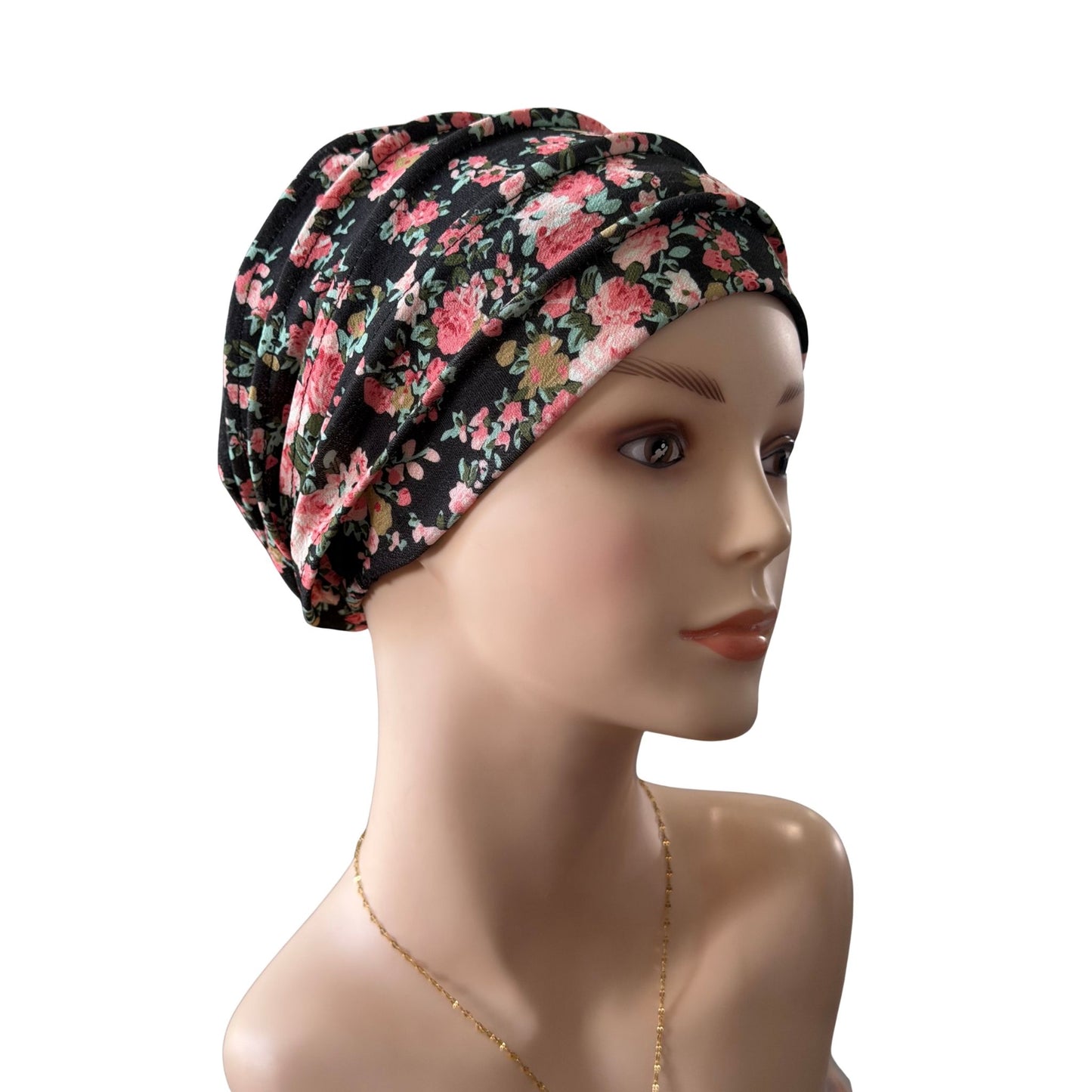 A floral-patterned turban-style headscarf displayed on a female mannequin head against a plain white background.