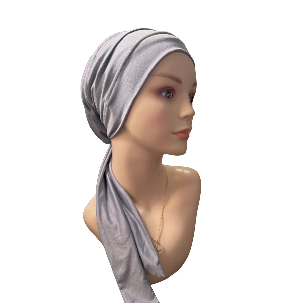 A light gray fabric headscarf or hijab wrapped around a female mannequin head and neck, shown against a plain white background.