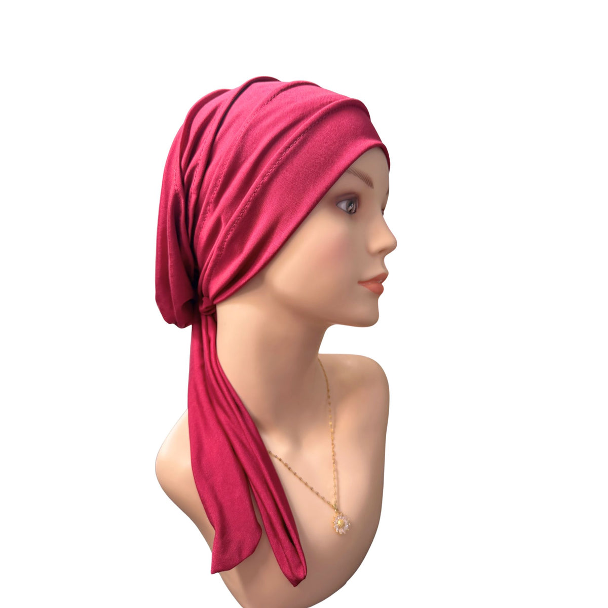 A wine red fabric headscarf wrapped around a mannequin head, shown in profile against a plain white background.