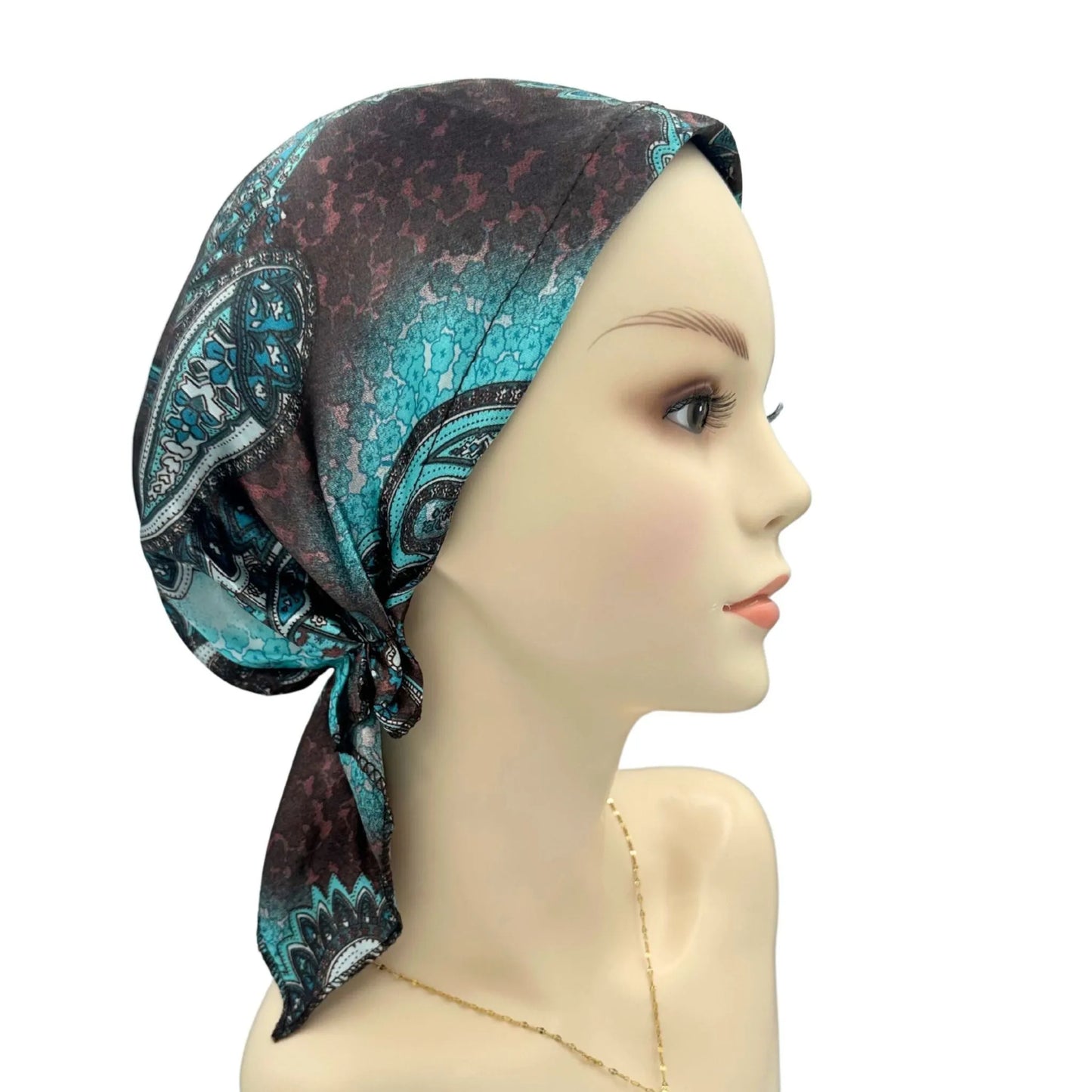 Mannequin head wearing a patterned headscarf on a white background