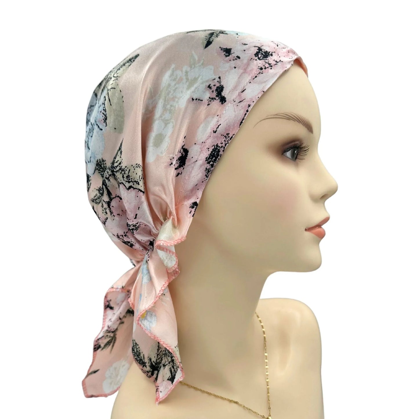 Mannequin head wearing a floral headscarf on a white background