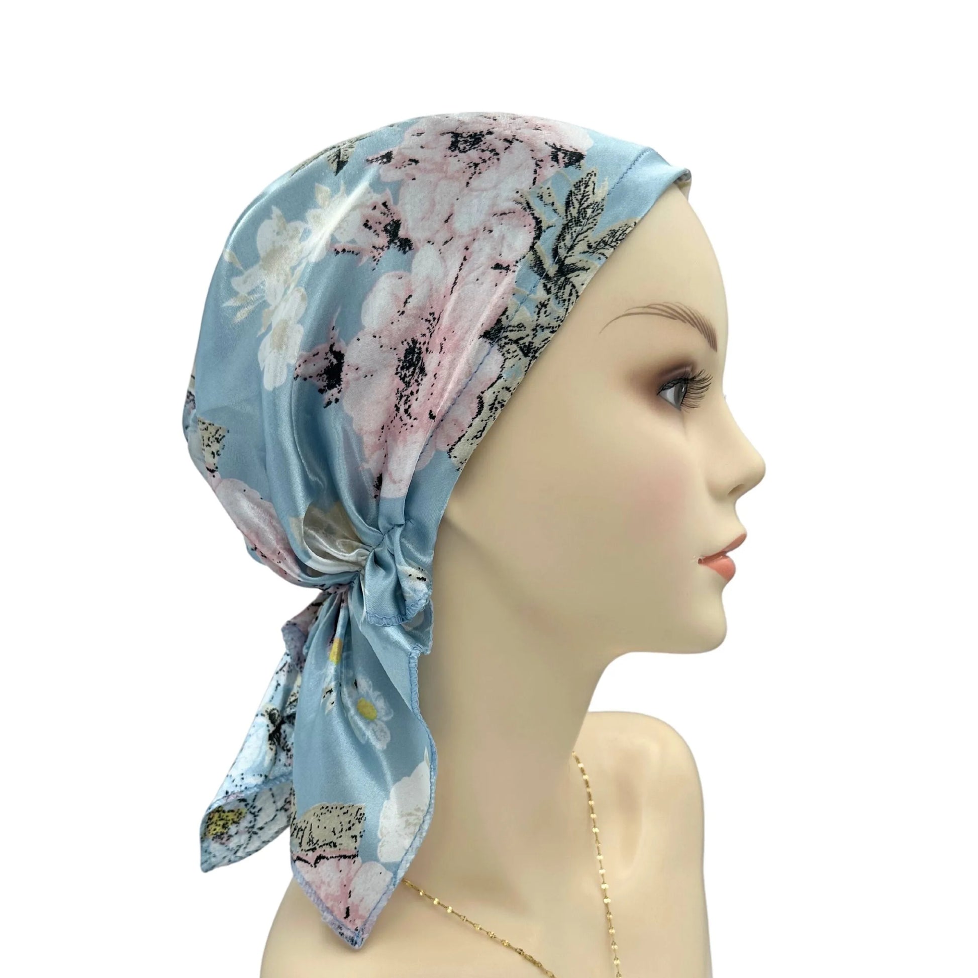 Mannequin head wearing a floral headscarf on a white background