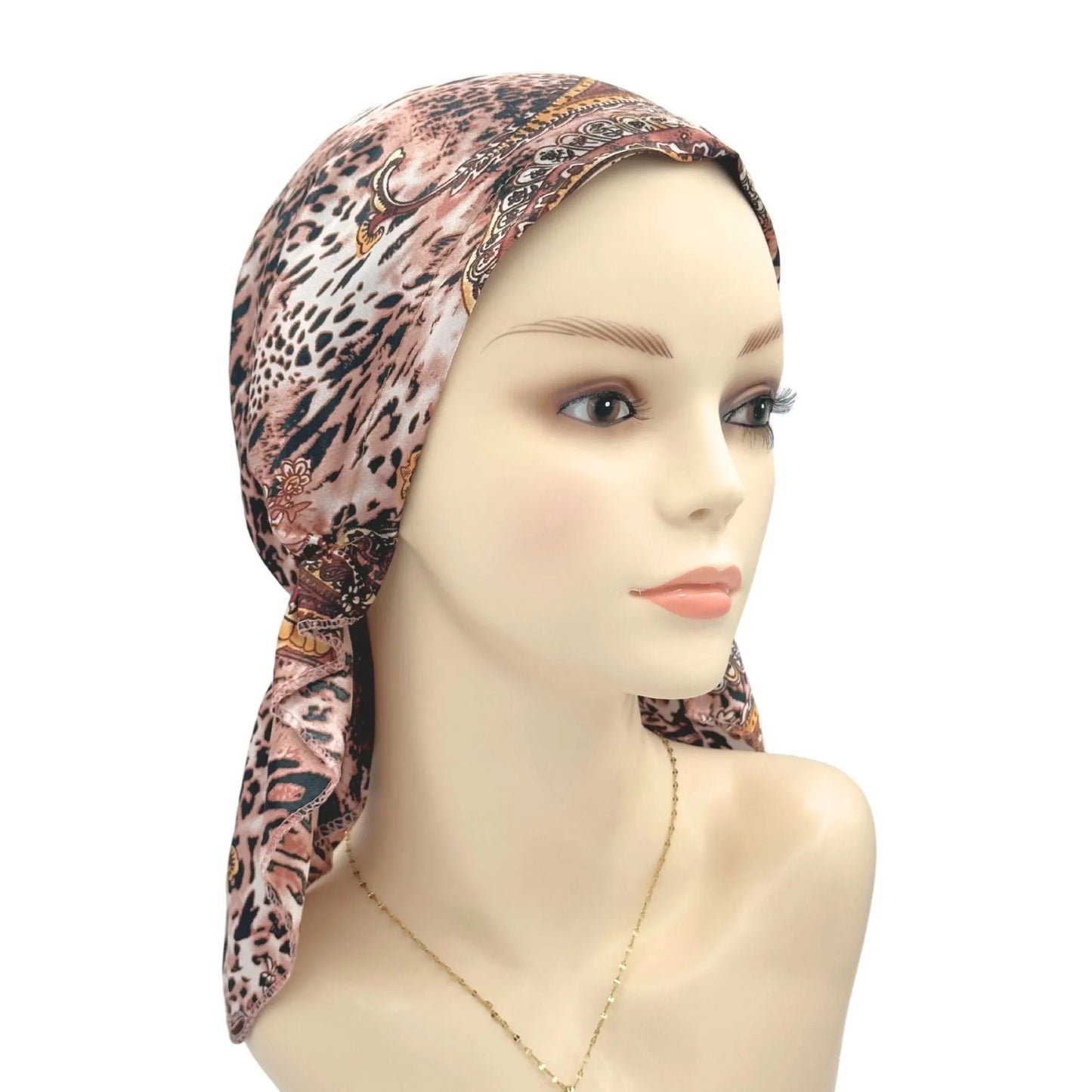 Mannequin head wearing a patterned headscarf on a white background