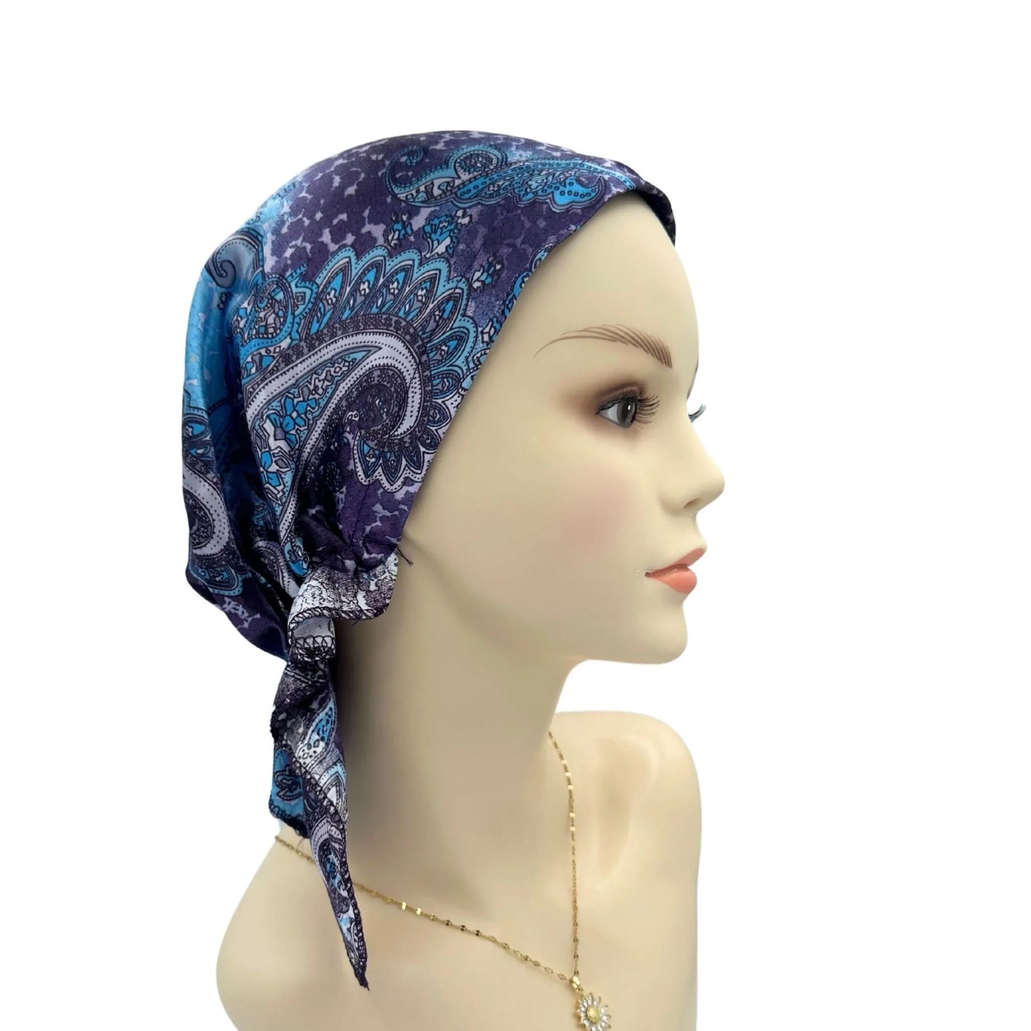 Mannequin head wearing a blue patterned headscarf on a white background