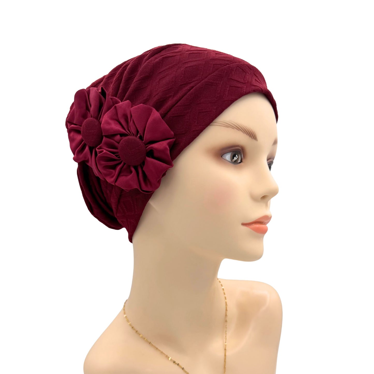 Red headscarf with a large flower on a mannequin head against a white background