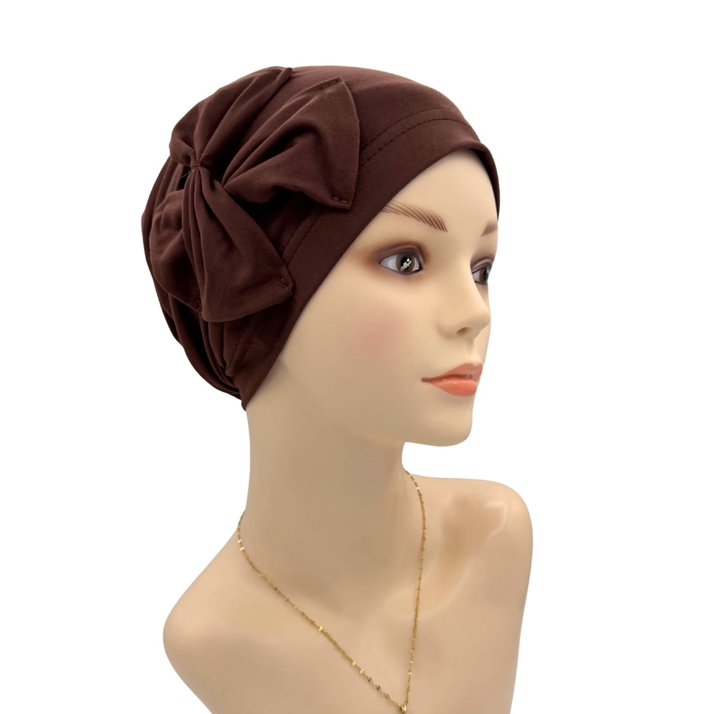 Brown headscarf with a bow on a mannequin head against a white background
