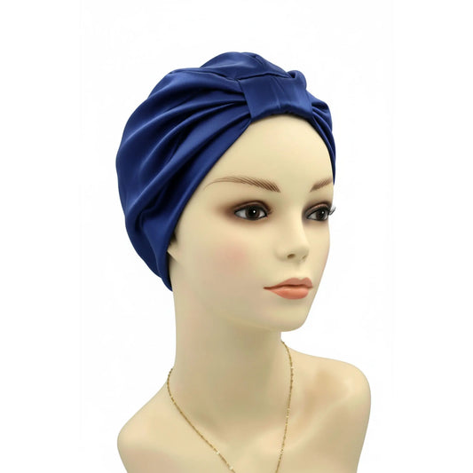 Mannequin head wearing a blue silk turban on a white background