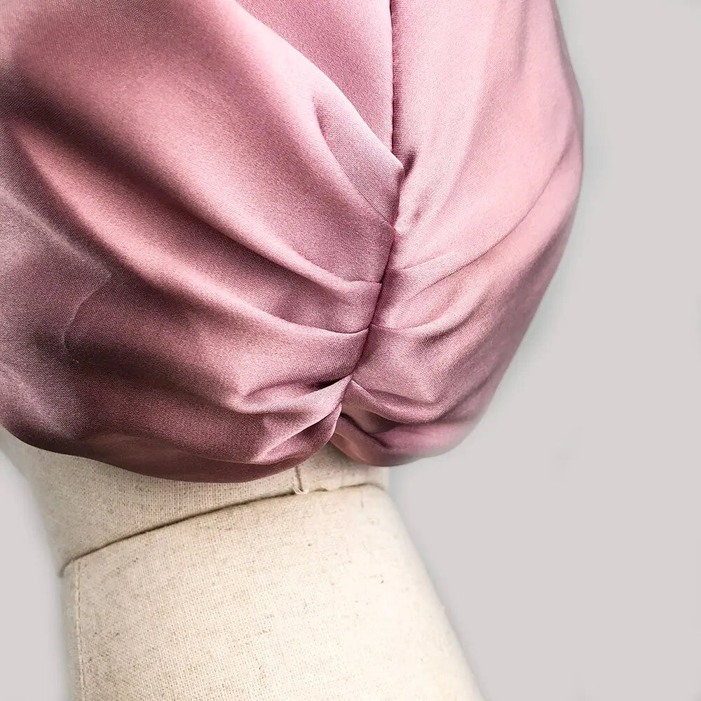 Close-up of a pink garment on a mannequin against a light gray background